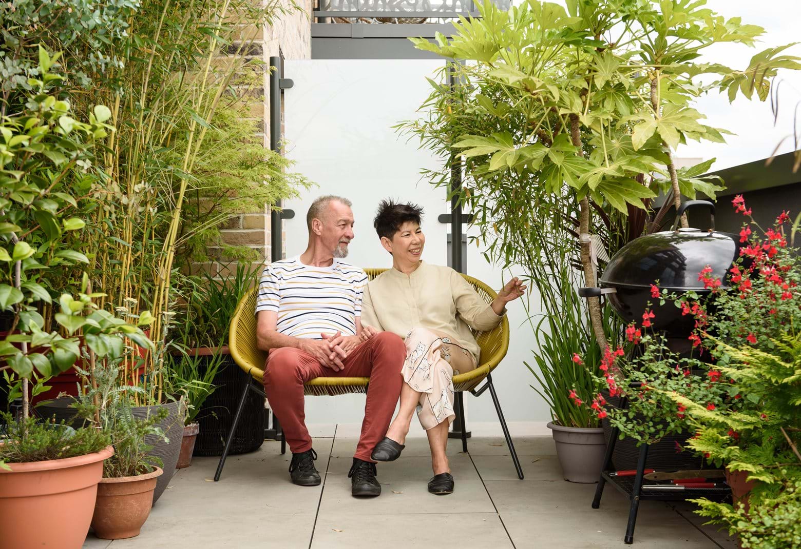 June and Greg enjoying their outdoor space filled with greenery at The Pomeroy