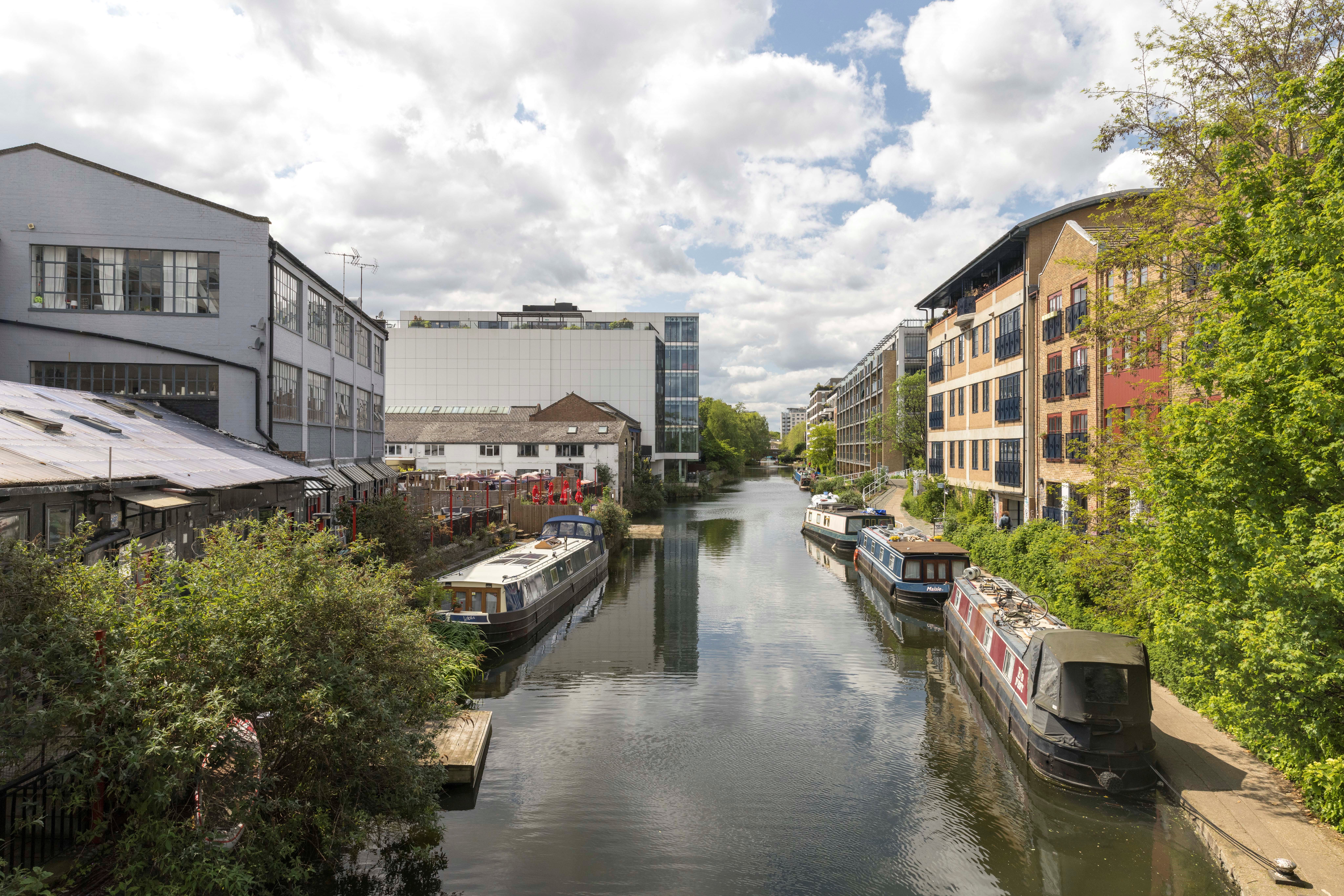 Boats in Regent's Canal bordered by appartment buildings and warehouses
